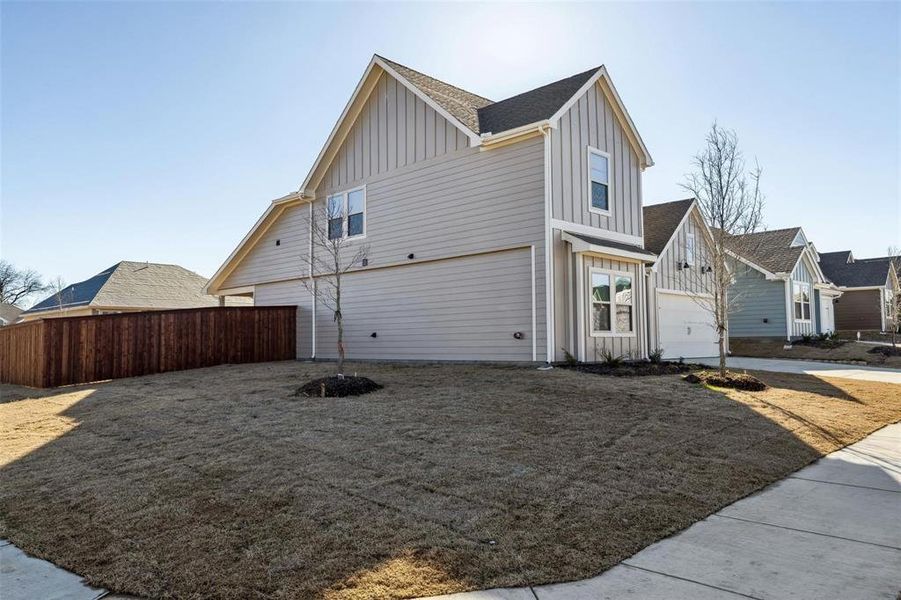 Contemporary architecture featuring board and batten gables, horizontal siding, an attached garage, and a private wooden fence