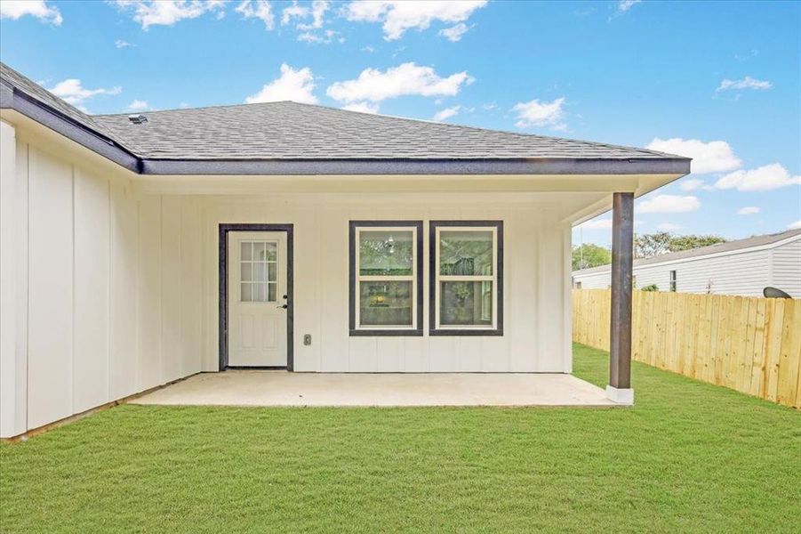 Doorway to property with a shingled roof and a patio area Doorway to property with a shingled roof and a patio area