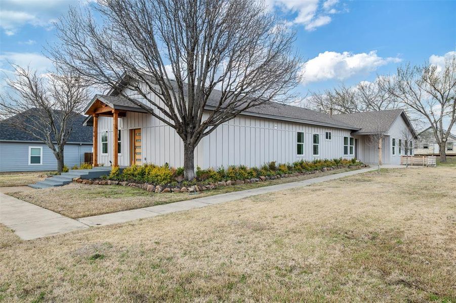 View of front of house with a front lawn and board and batten siding