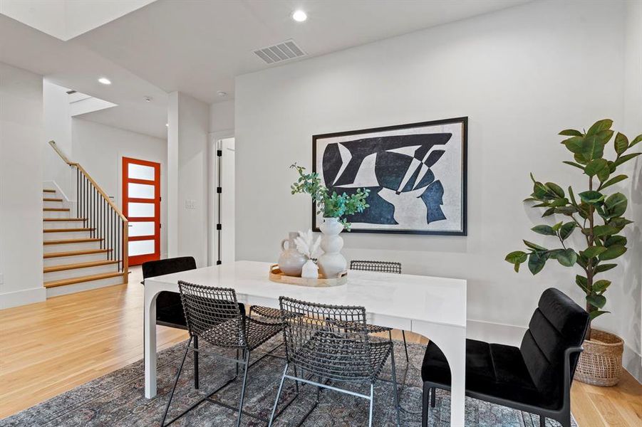Dining space with wood finished floors, recessed lighting, and stairway Dining space with wood finished floors, recessed lighting, and stairway
