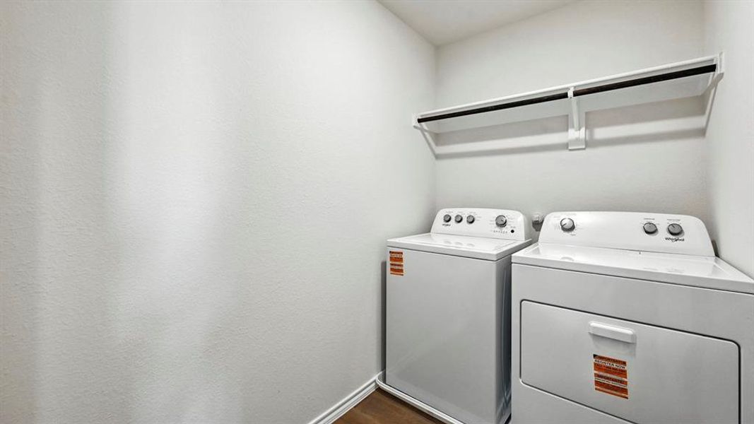 Dedicated laundry area featuring a wall-mounted drying rack and wood-finish flooring