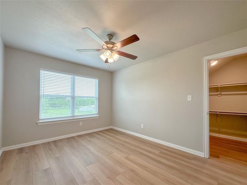 Empty room with light hardwood / wood-style floors and ceiling fan