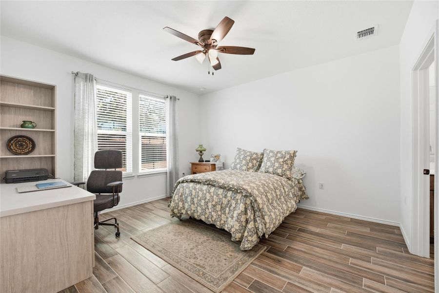 Bedroom featuring a desk, wood tiled floors, and ceiling fan