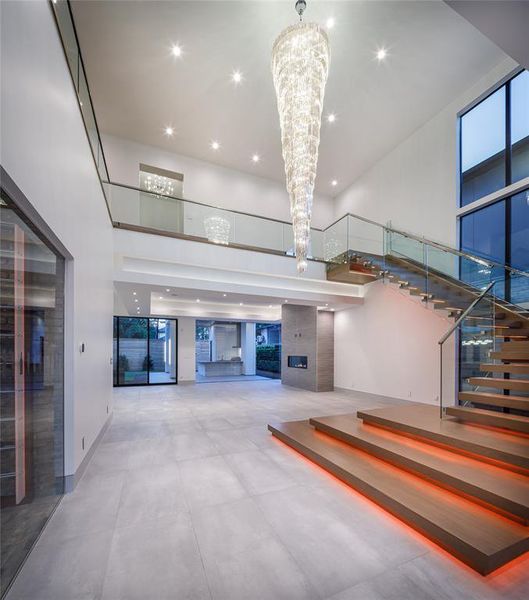 Quality craftsmanship & extraordinary details marked by exquisite interior, timeless elegance and a floating custom-built staircase with LED lit hardwood treads, glass railing and a spectacular 14' vertical crystal chandelier