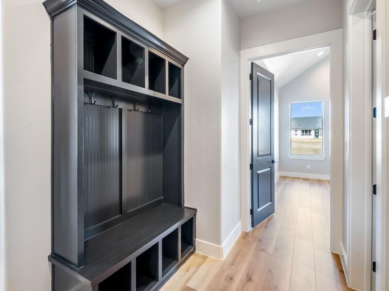 Mudroom with lofted ceiling and light wood-type flooring