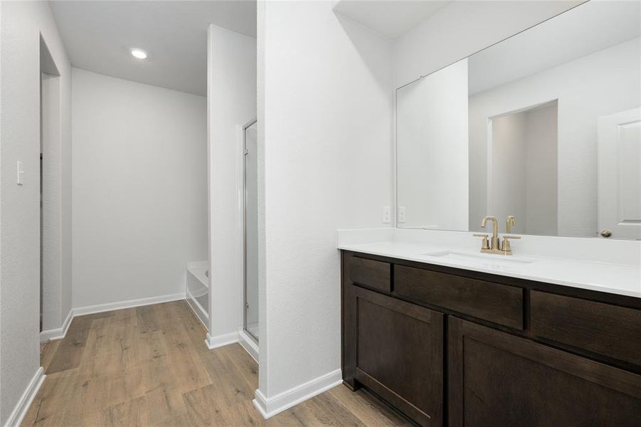 Full bathroom with vanity, light wood-style floors, a stall shower, a bath, and recessed lighting