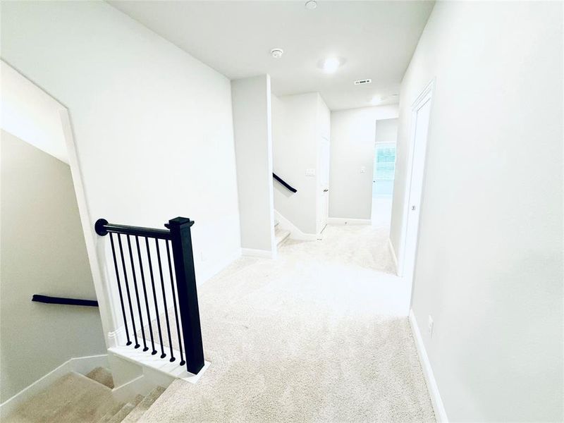 Upper-level hallway with light-toned carpeting and neutral wall finishes