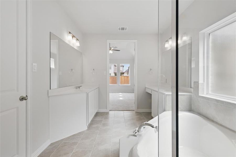 Bathroom featuring vanity, a ceiling fan, visible vents, a garden tub, and tile patterned flooring Bathroom featuring vanity, a ceiling fan, visible vents, a garden tub, and tile patterned flooring