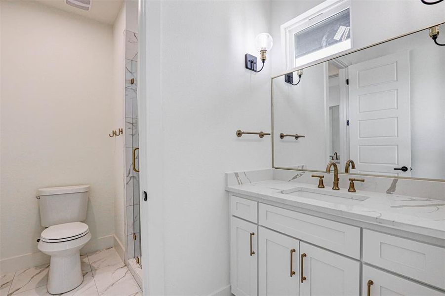 Bathroom featuring vanity, toilet, tile patterned flooring, and an enclosed shower