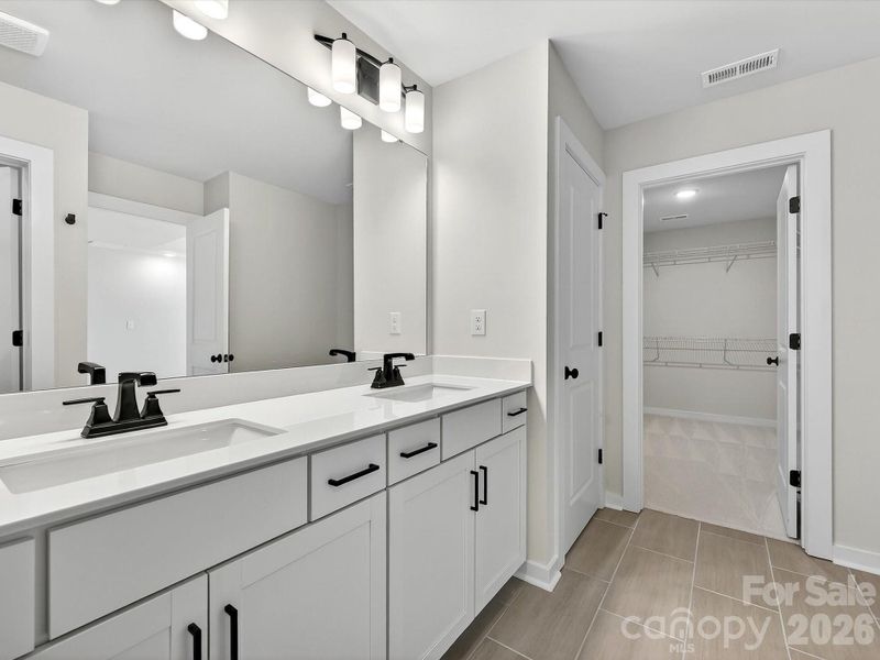 primary bath with large, tiled shower with bench, dual vanity with soft close doors & drawers, Quartz countertops. Separate WC