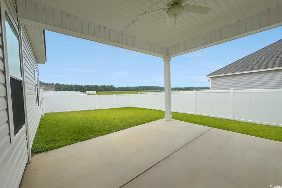Fenced backyard featuring a patio area and ceiling fan