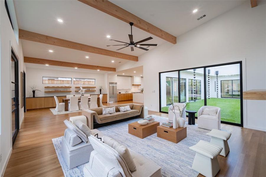 Living room with beamed ceiling, high vaulted ceiling, light hardwood / wood-style flooring, and ceiling fan