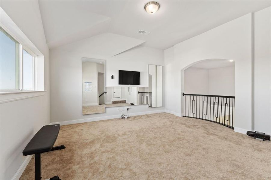 Unfurnished living room featuring lofted ceiling and carpet