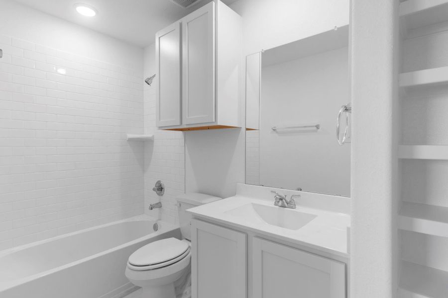 Upstairs full bath with tub/shower combo, modern fixtures, and ample storage cabinets.