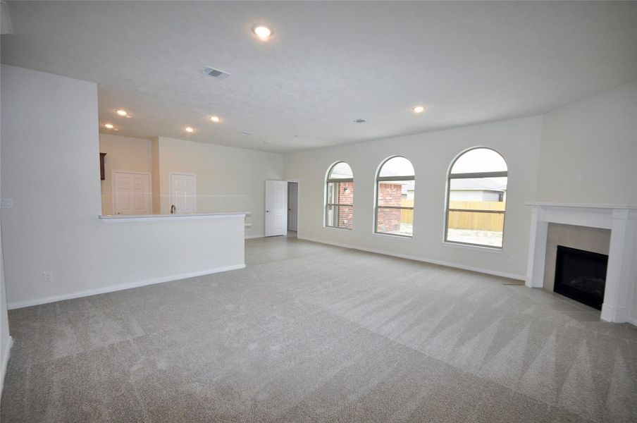 Remotely controlled and directly vented gas fireplace is viewable from the kitchen sink area.