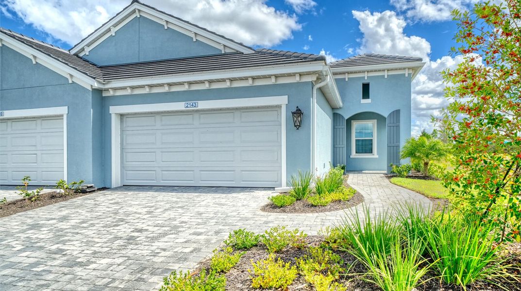 Front exterior of a new home in Palm Grove, Lakewood Ranch, FL, highlighting curb appeal (Image 1). Front exterior of a new home in Palm Grove, Lakewood Ranch, FL, highlighting curb appeal (Image 1).