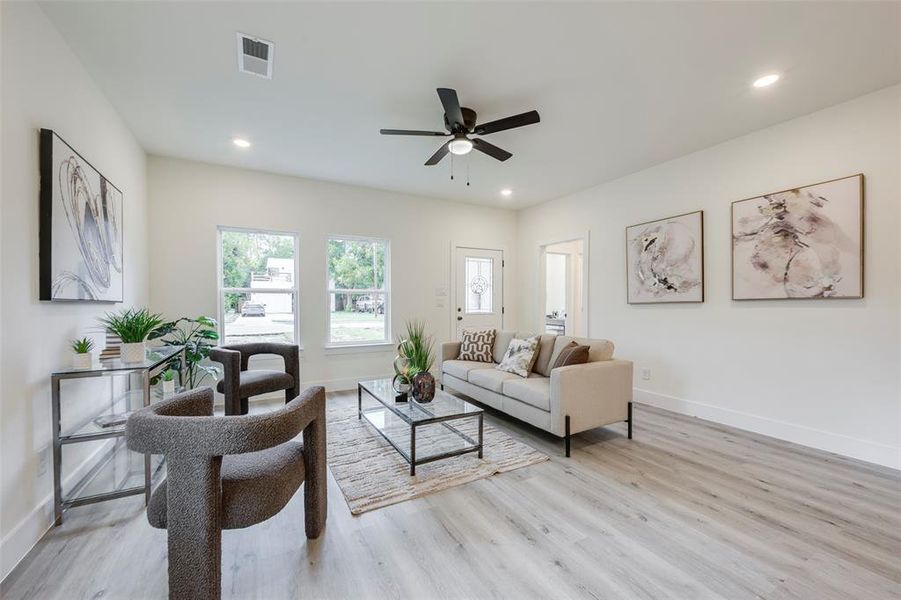 Living area with light wood finished floors, recessed lighting, and a ceiling fan