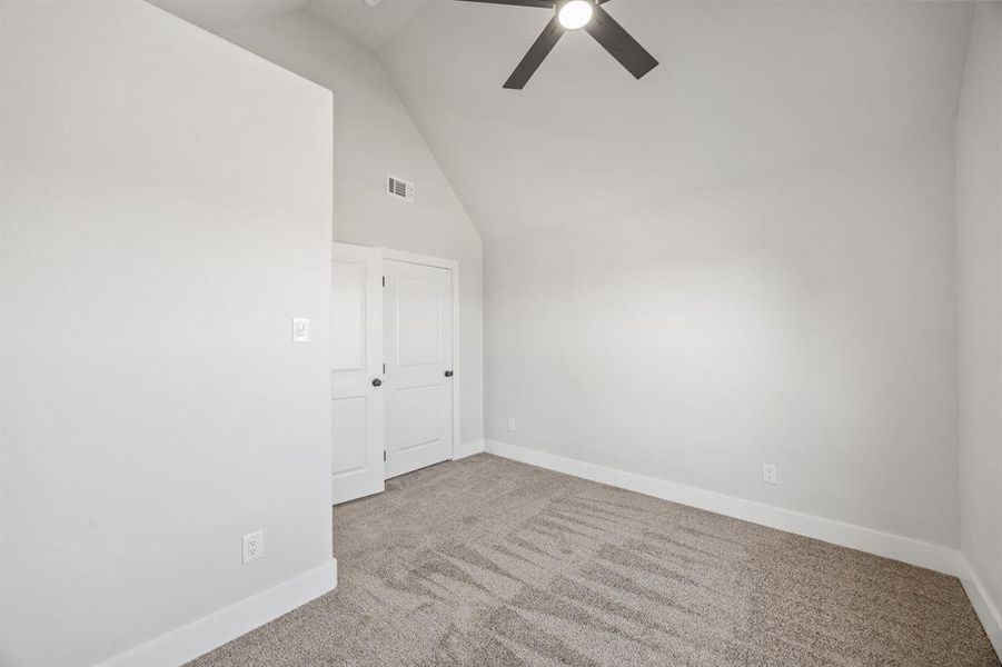 Carpeted spare room with high vaulted ceiling and ceiling fan