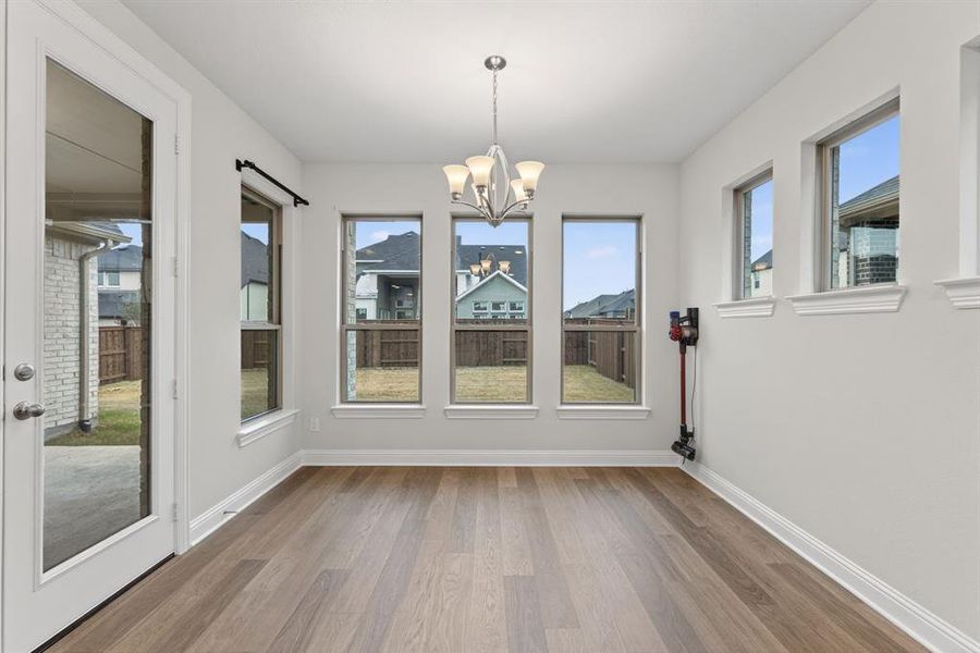 Unfurnished dining area with a chandelier, plenty of natural light, and light wood-style floors Unfurnished dining area with a chandelier, plenty of natural light, and light wood-style floors