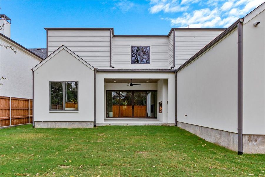 Back of property with ceiling fan, a patio area, and stucco siding