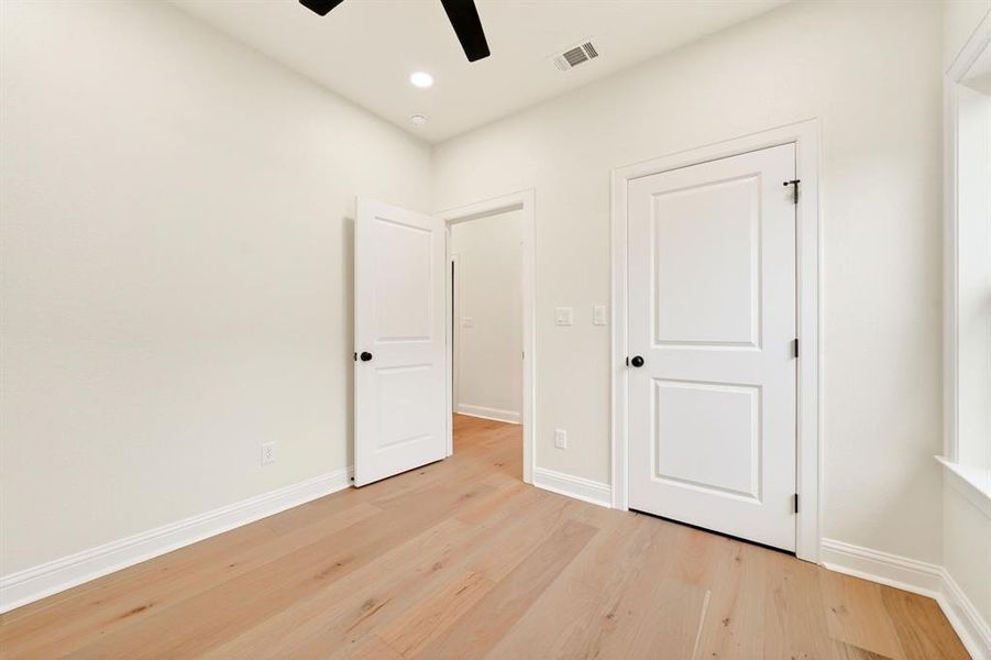 Room featuring light-toned wood-finish flooring, white baseboards, and neutral wall paint