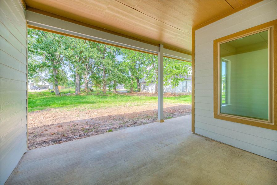 a covered back patio with concrete flooring