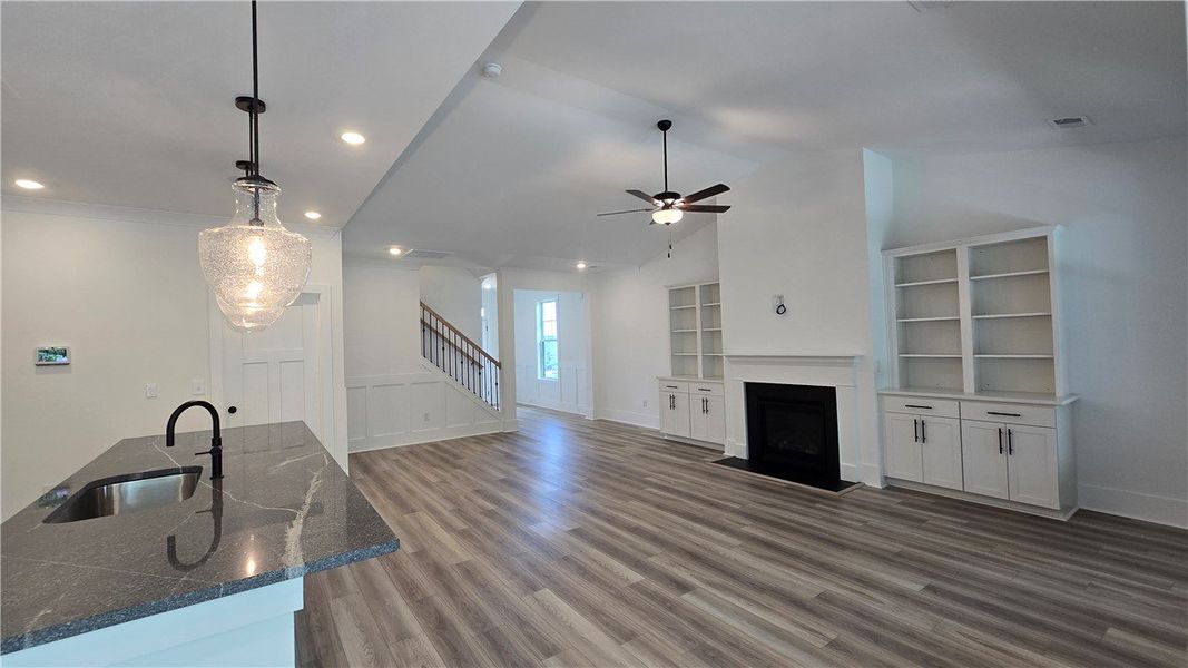 An open-concept living area features wide plank fl