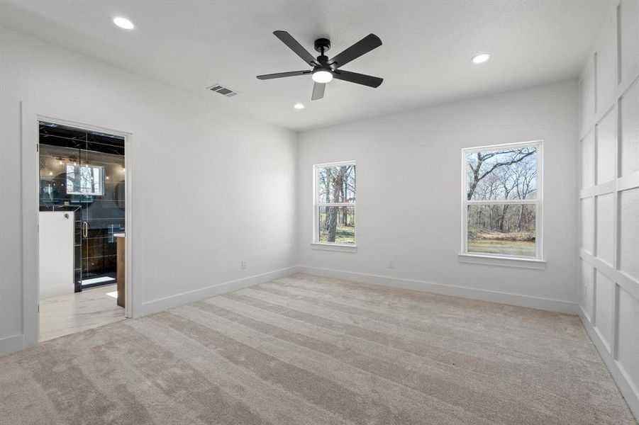 Carpeted spare room featuring ceiling fan