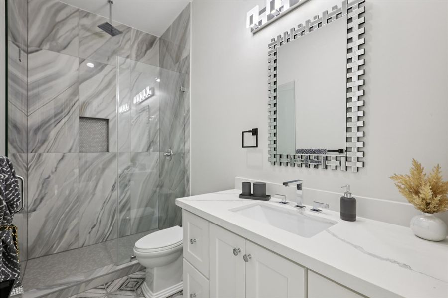 Bathroom with vanity and a marble finish shower