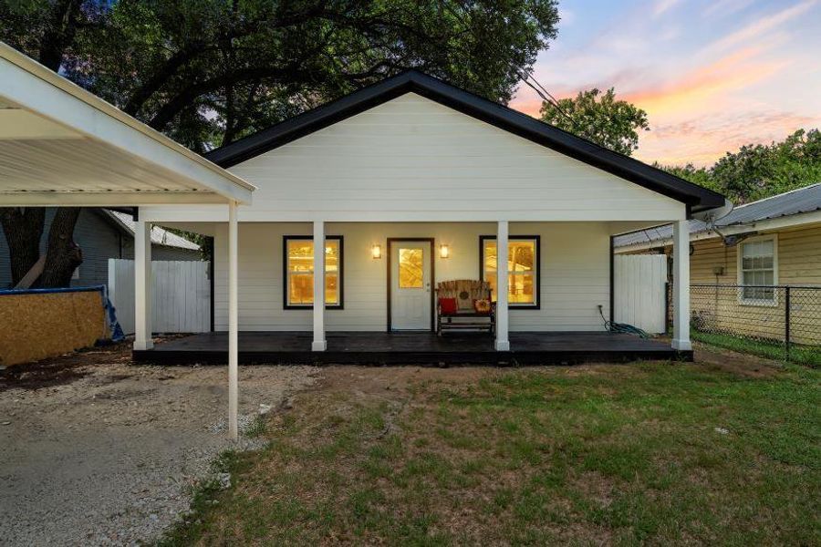 Back of house at dusk with a porch Back of house at dusk with a porch