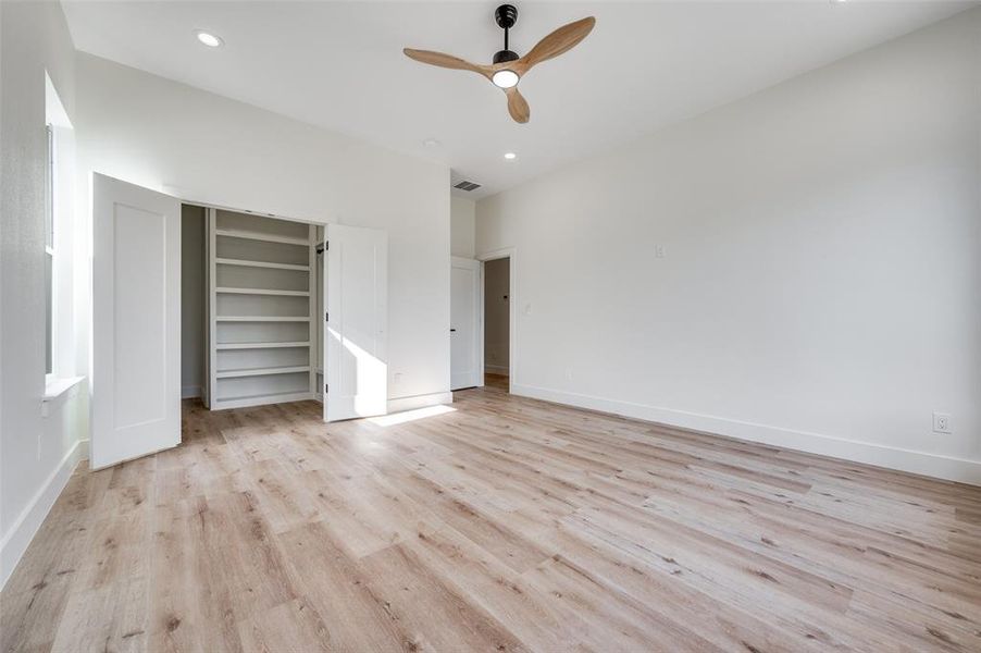 Unfurnished bedroom featuring light wood-style flooring, ceiling fan, a closet, and recessed lighting