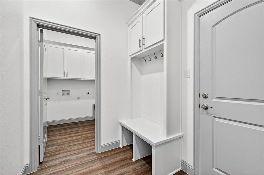 Mudroom with dark wood-type flooring and baseboards