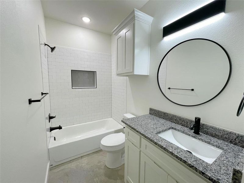 Full bathroom featuring vanity, toilet, and tiled shower / bath