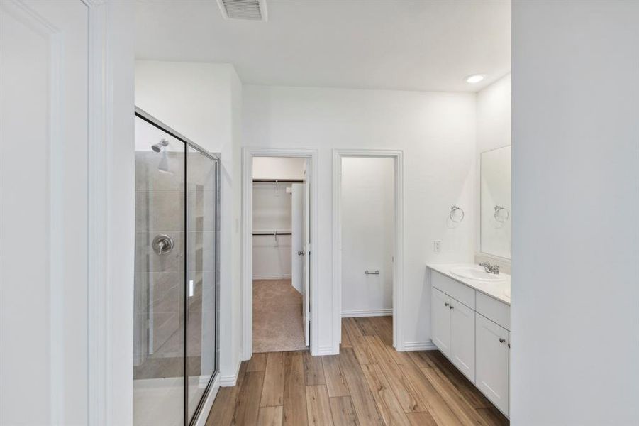 Bathroom with vanity, an enclosed shower, and hardwood / wood-style flooring