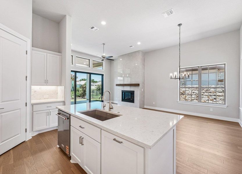 Kitchen featuring a fireplace, a ceiling fan, light wood-type flooring, open floor plan, and recessed lighting