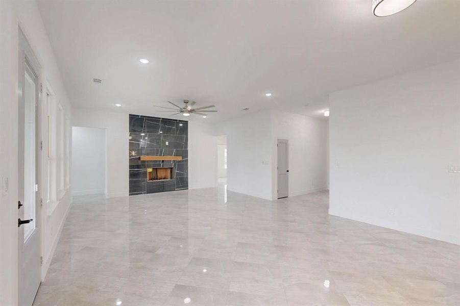 Unfurnished living room featuring recessed lighting, a ceiling fan, and a premium fireplace