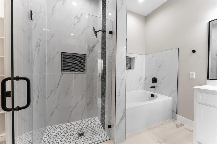 Bathroom featuring vanity and shower with separate bathtub