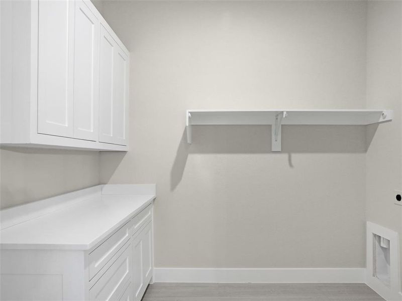 Laundry room with cabinets, light hardwood / wood-style floors, and electric dryer hookup