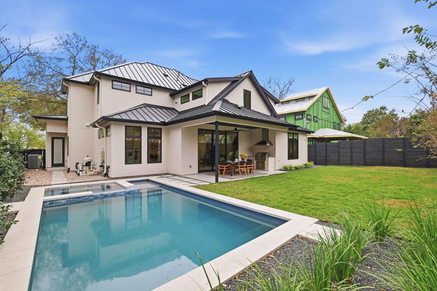 Rear view of property featuring a standing seam roof, a patio area, a metal roof, and stucco siding