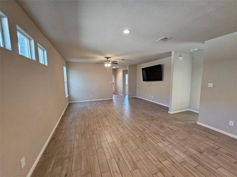 Living area featuring wood looking tile floors, ceiling fan and moldings.