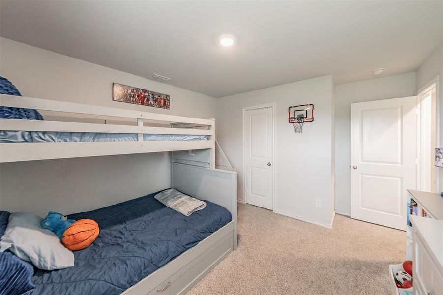 Carpeted room with light-toned walls and recessed lighting