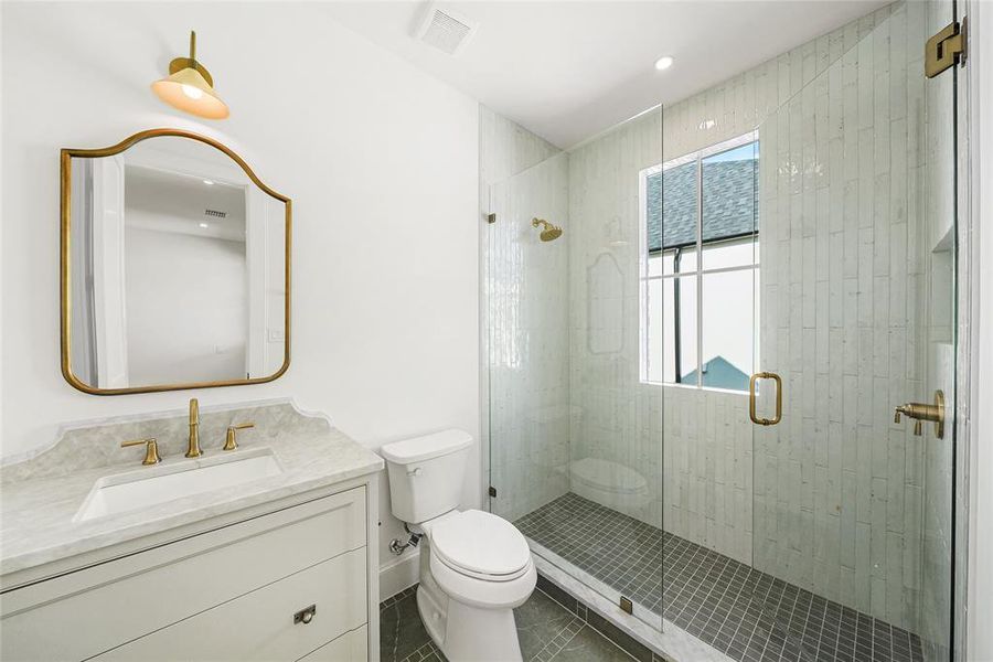 Bathroom featuring a glass-enclosed shower with vertical white tile, dark gray mosaic floor tile, and a built-in shower niche