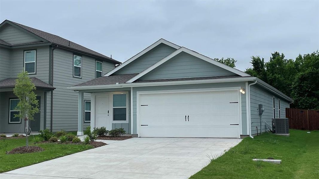 Single-story residence featuring light blue horizontal siding, a white front door, and a two-car garage with a concrete driveway Single-story residence featuring light blue horizontal siding, a white front door, and a two-car garage with a concrete driveway