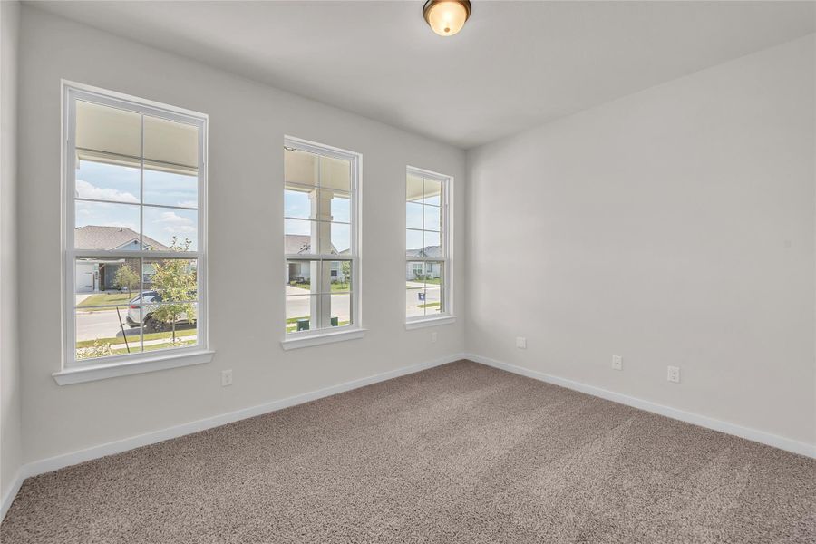 Carpeted spare room featuring baseboards Carpeted spare room featuring baseboards