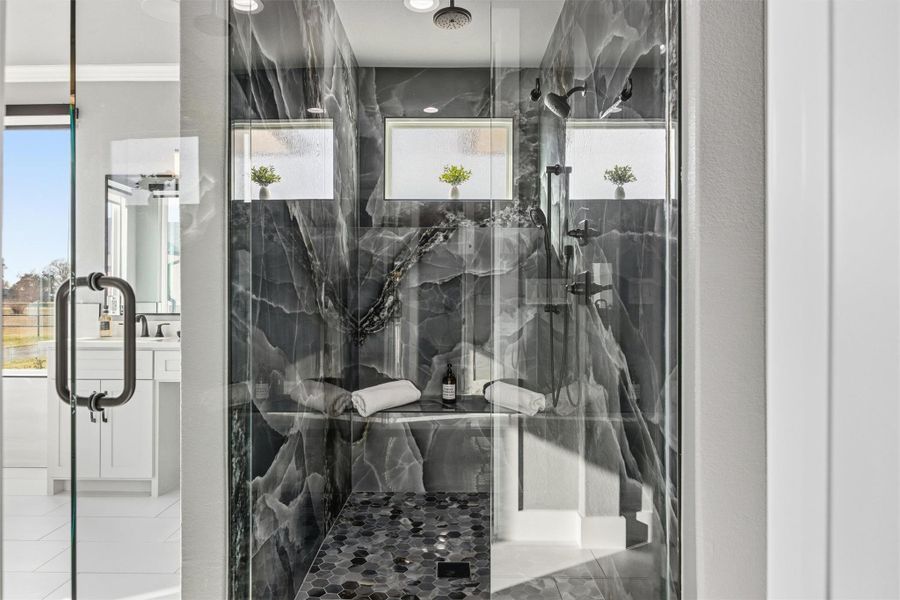 Full bath with vanity, plenty of natural light, and a marble finish shower