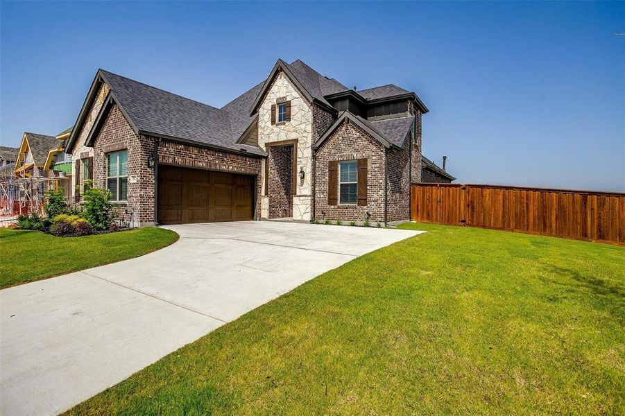 View of front of property with a garage and a front lawn