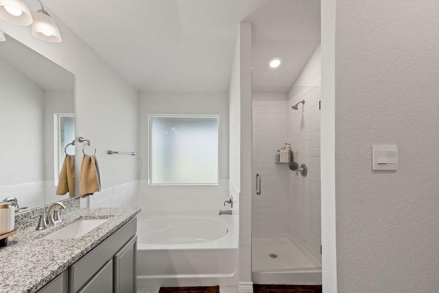Full bath featuring a bath, vanity, and a shower stall
