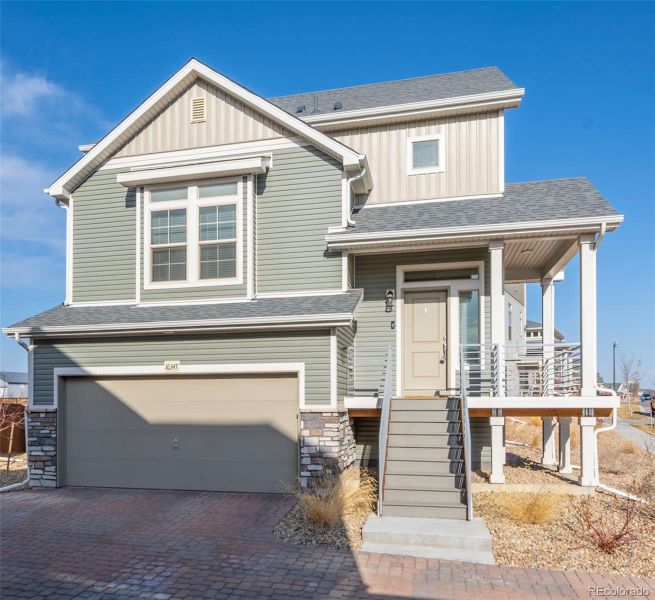 Front exterior of a new home in Reunion, Commerce City, CO, highlighting curb appeal (Image 1).