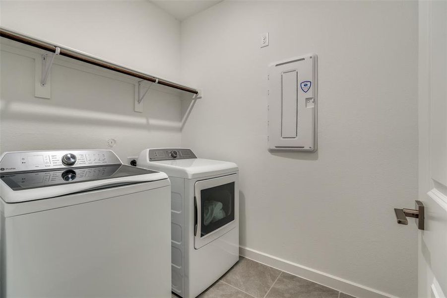 Laundry room with light tile patterned floors, electric panel, and separate washer and dryer Laundry room with light tile patterned floors, electric panel, and separate washer and dryer