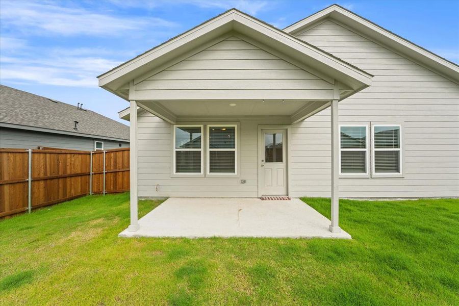 Back of house featuring a yard and a patio area